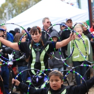 Gretchen (top) and a young dancer mirror each other as they use their hoops as wings in the hoop dance, Oct. 6, at the Ojibwe Drum and Dance Troop performance at the Apple Festival in Bayfield, Wisc.